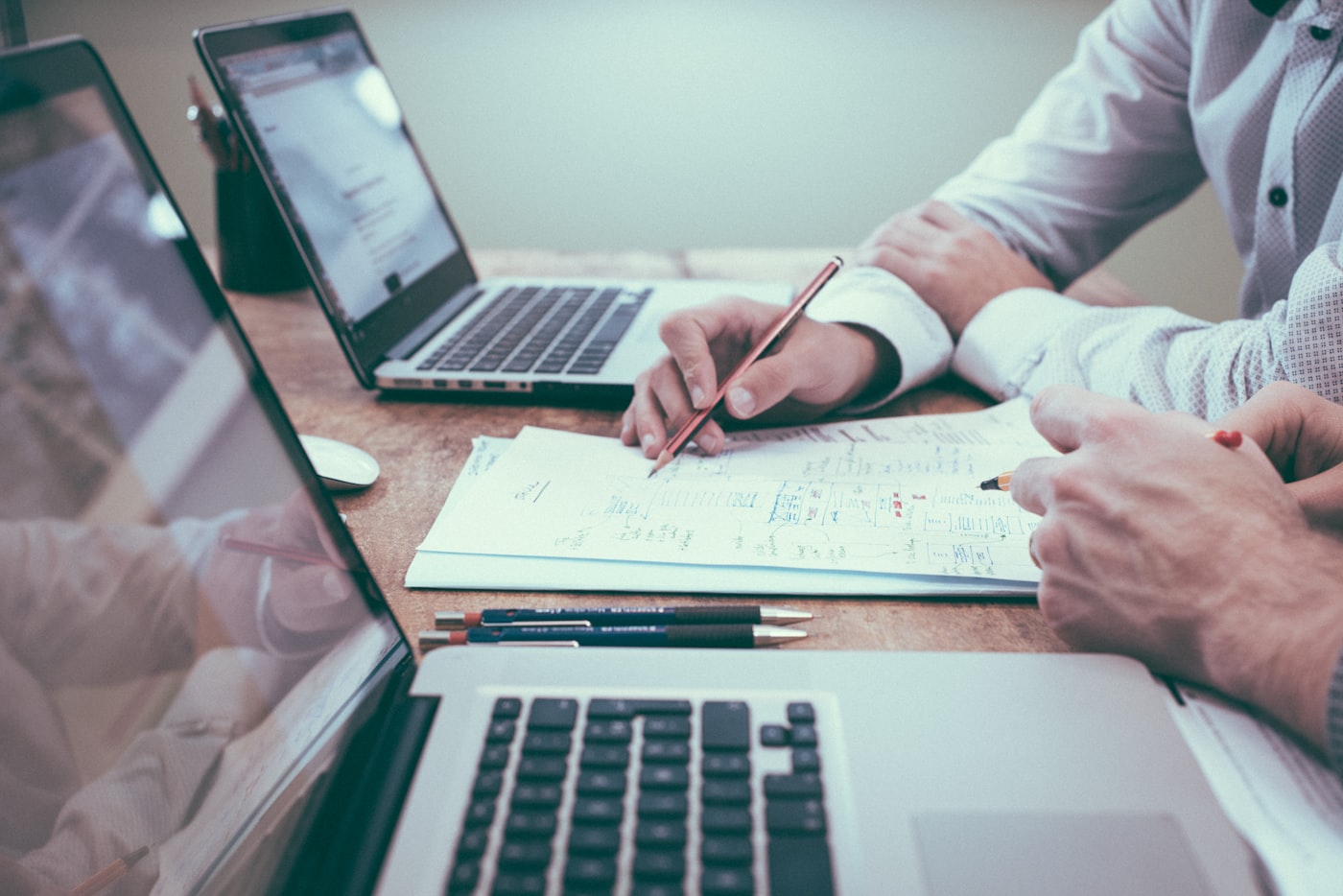Researcher defining paper screening criteria beside a laptop